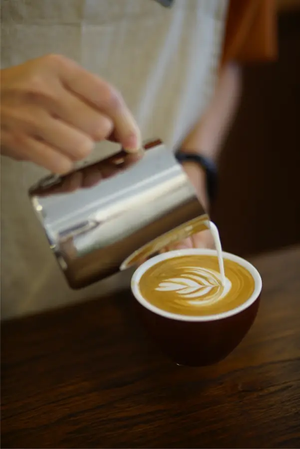 Latte art being poured by hand at baan125 hangout